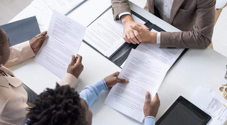 Advisor handing out letters to couple at a desk