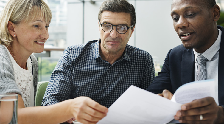 Advisor meeting with middle aged couple looking at documents