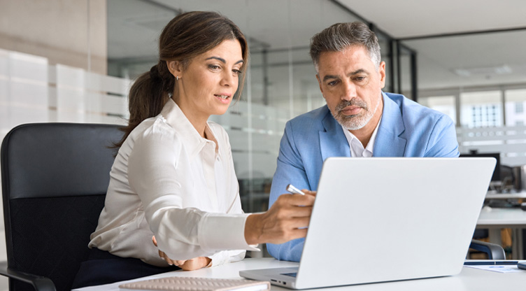 Client and advisor meeting looking at laptop on office