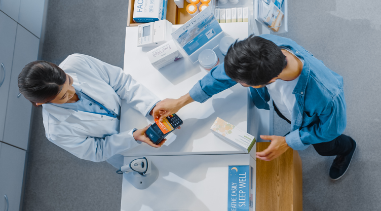 man paying for his meds at a pharmacy