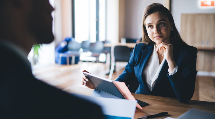Woman advisor chatting with client and holding laptop