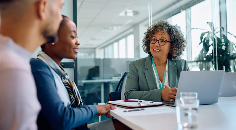 Woman advisor meeting young couple in office