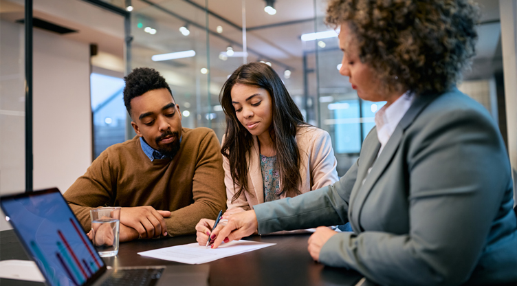 Woman meeting with young couple and signing documents