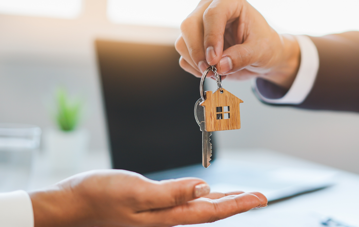 man handing a woman keys to a home