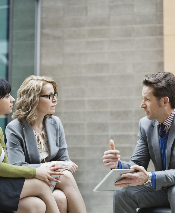 man holding ipad having conversation with two women