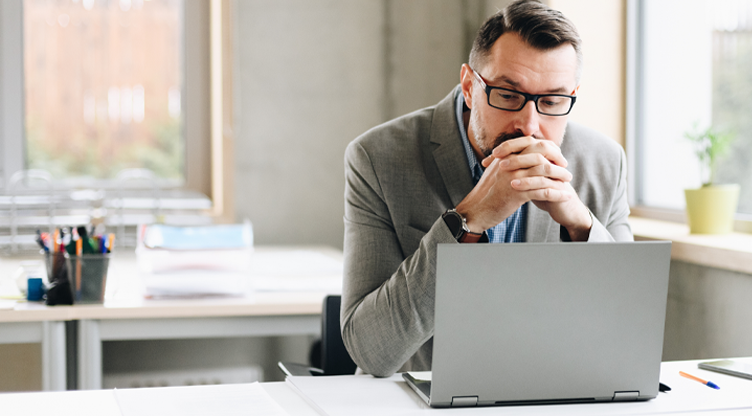 man in a suit looking concerned at his laptop