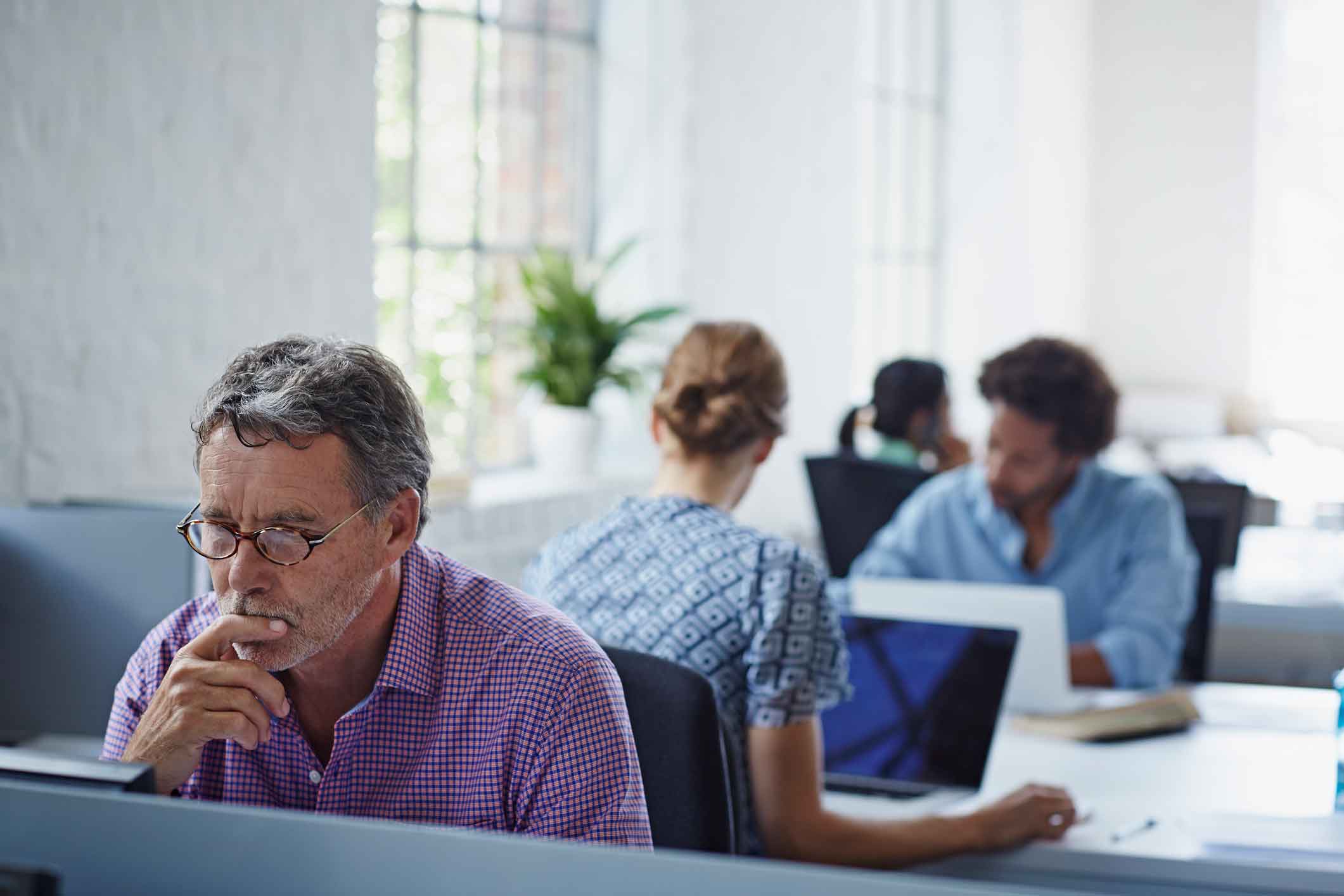 man in purple shirt looking at computer