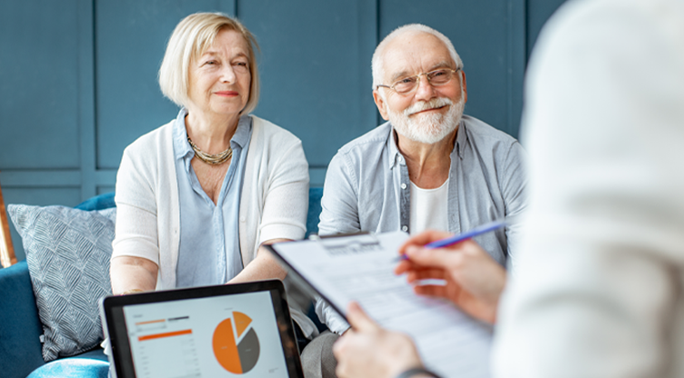 Older couple sitting down with a financial advisor taking a survey