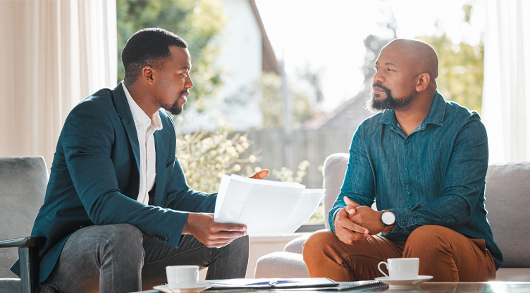 two men having coffee looking at documents