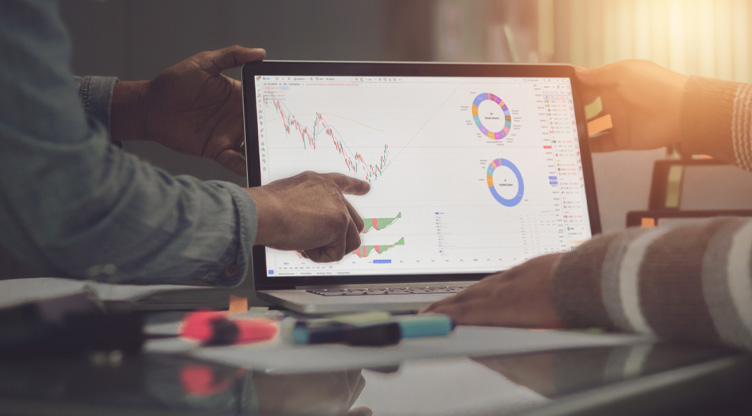 two people looking at the markets on a tablet